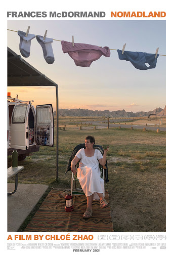 woman sitting in a chair outside with clothesline above her