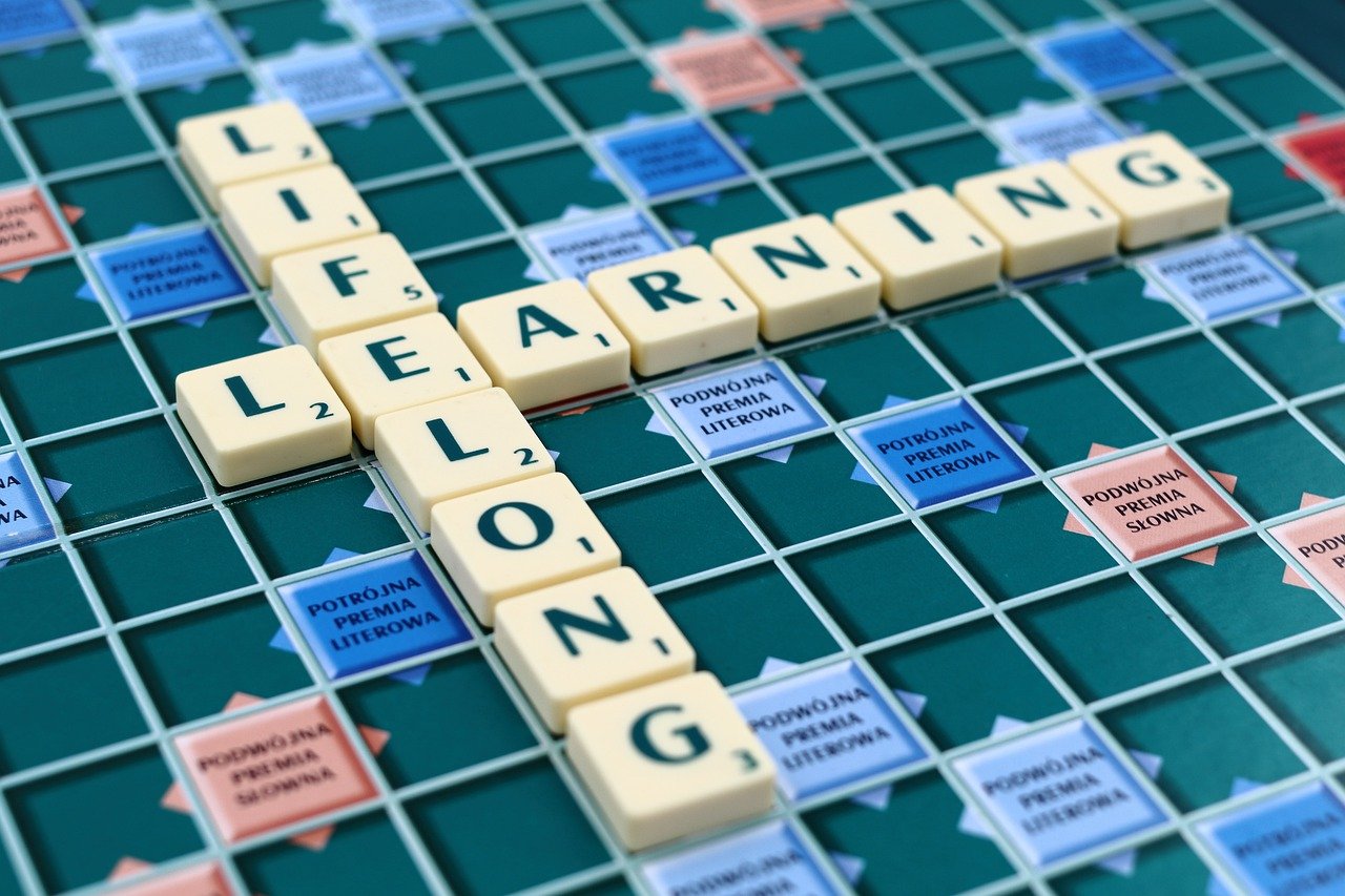 scrabble board with tiles that spell lifelong learning