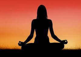 silhouette of a woman in a seated yoga position