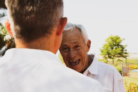 Older man greeting a younger man