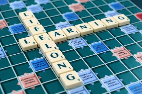 scrabble board with tiles that spell lifelong learning