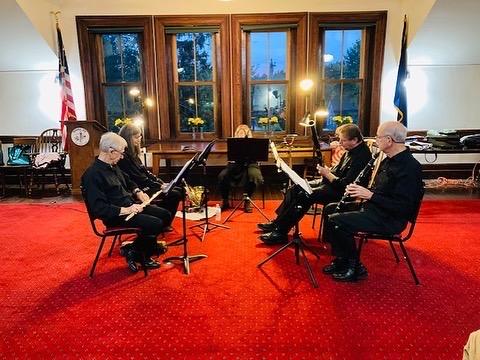 Four musicians on woodwind instruments performing