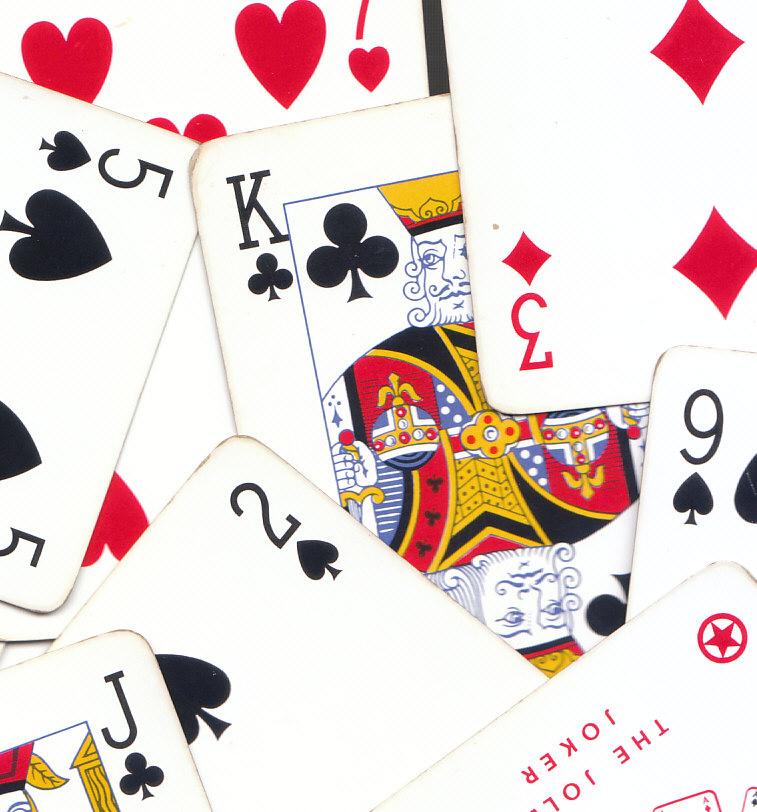 overhead shot of playing cards with a king of clubs in the center