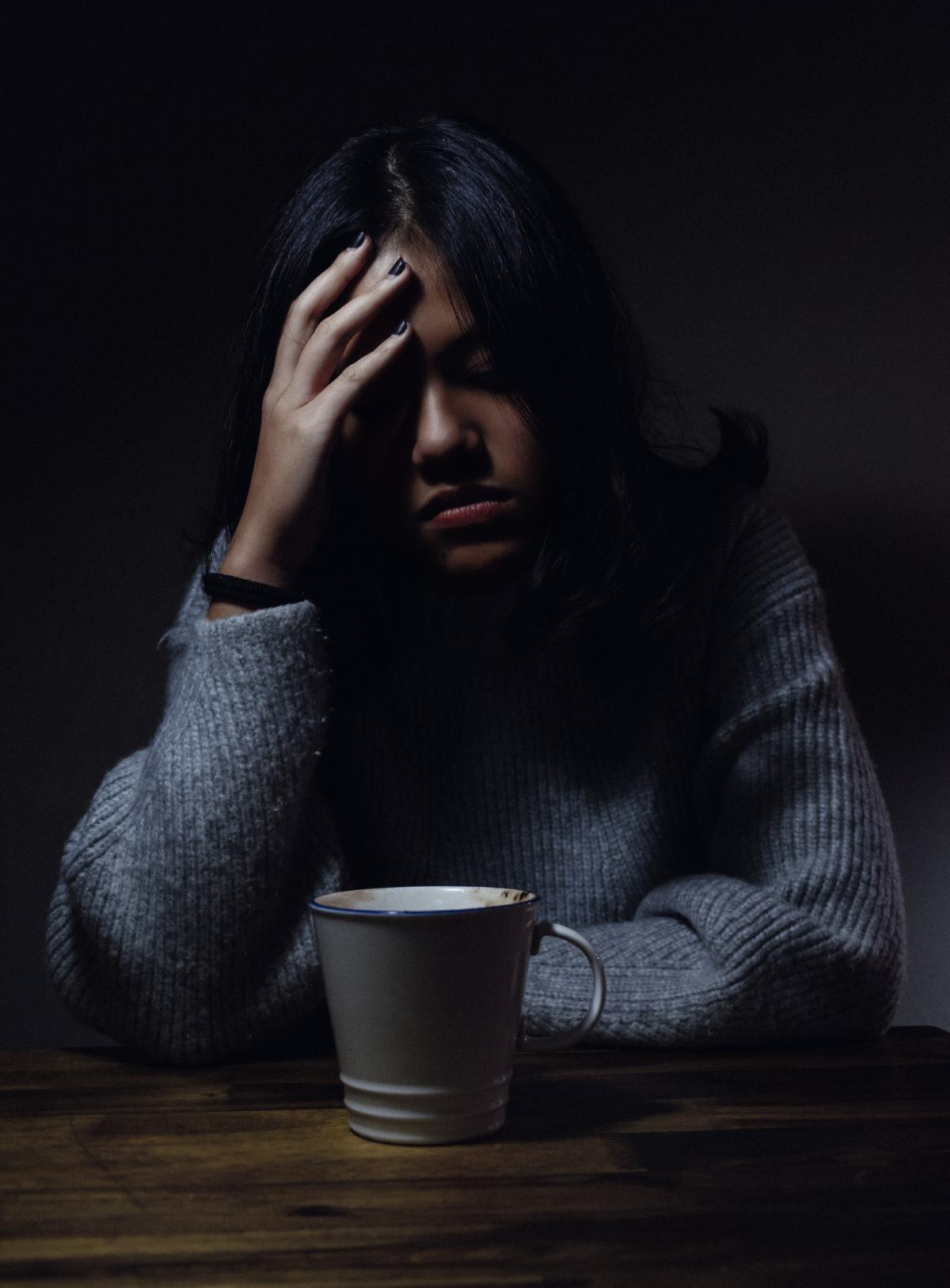 woman holding her head in pain