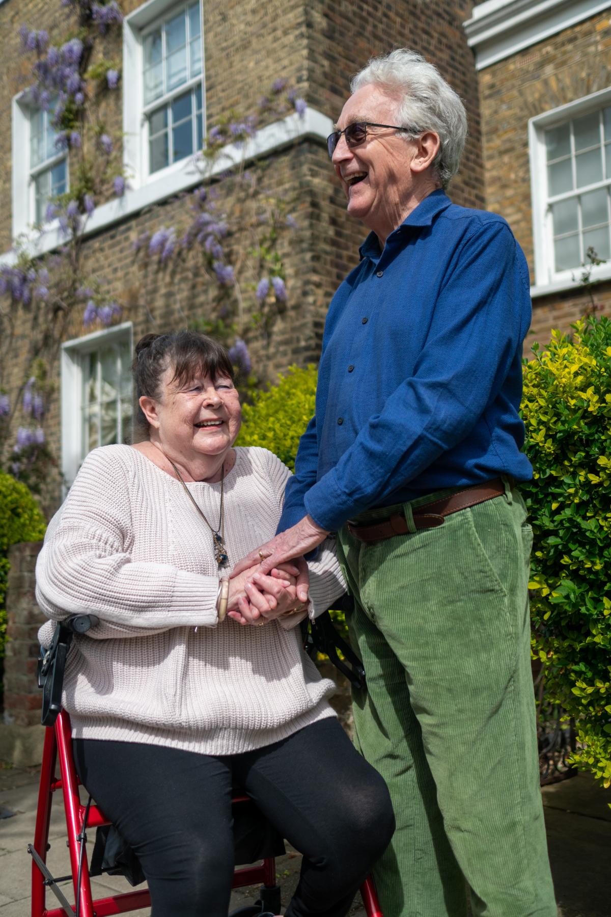 woman in walker and standing man laughing