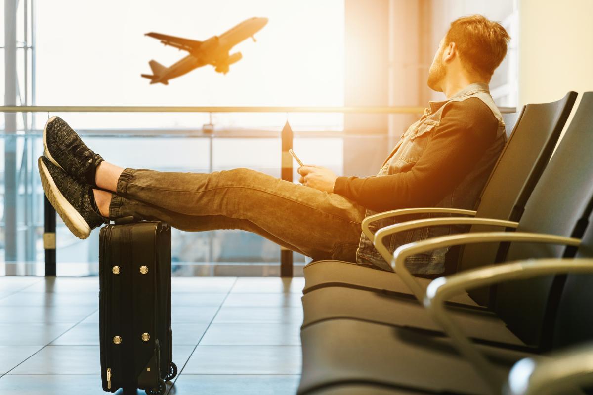 man looking out at a plane at the airport