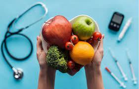 fruit in hands with diabetes equipment around it