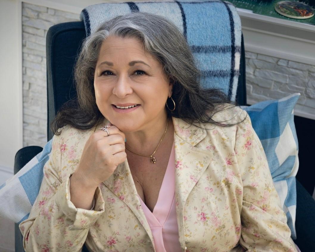 grey haired female in yellow flower suit 