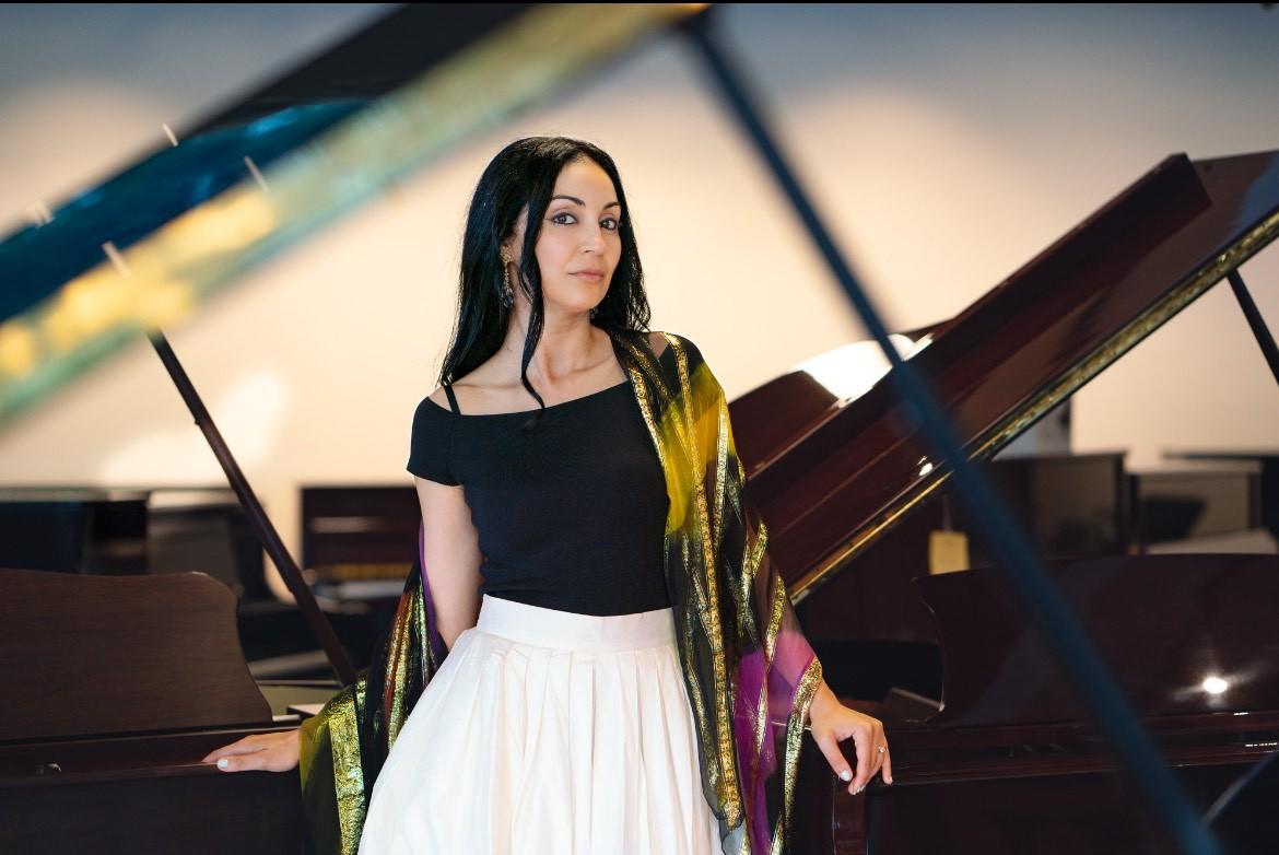 Jenny in front of a beautiful piano